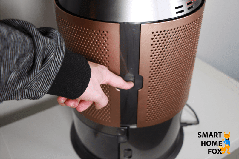 Der Schieberegler an der Seite des Luftgitters vom Dyson Purifier Humidify+Cool Formaldehyde PH04 wird nach unten gedrückt.